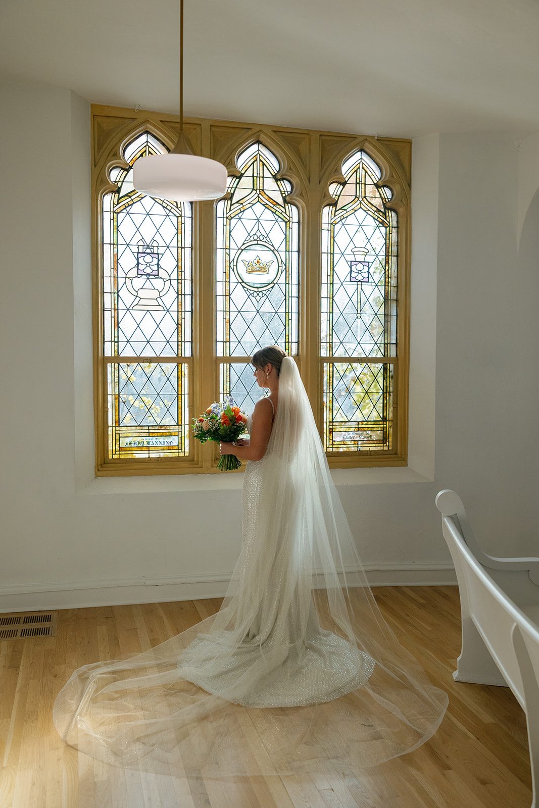 Wedding ceremony beneath the original stained glass at Melrose Abbey, a 1922 Gothic church in Kansas City