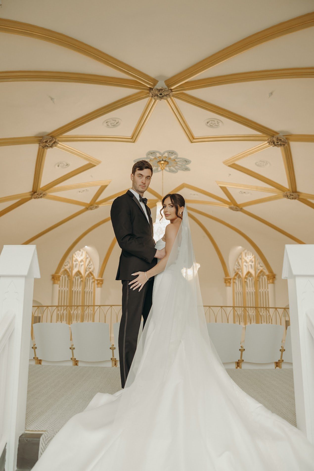 Couple portrait beneath the arches of the restored 1922 church